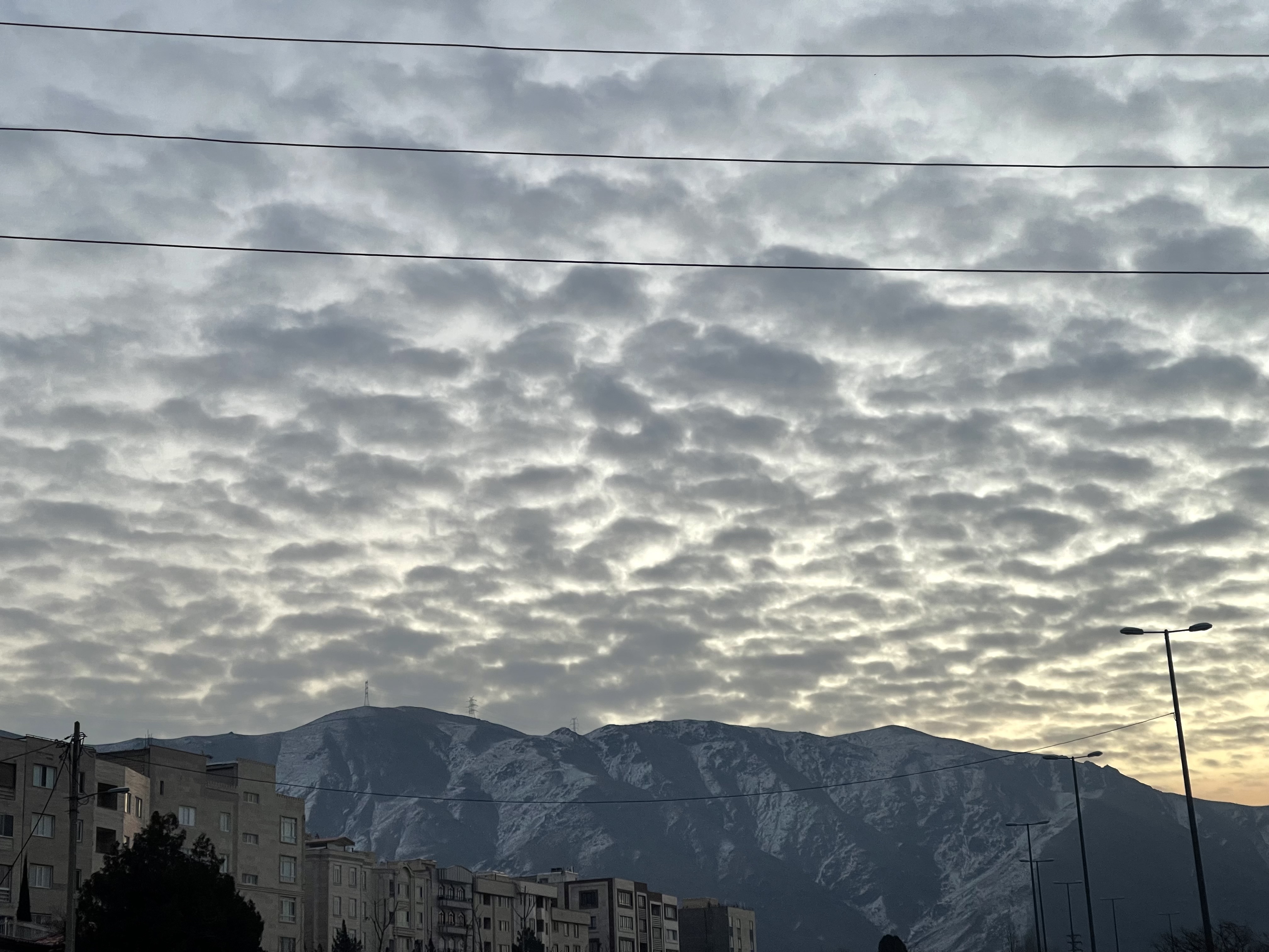 ابرها مثل پنبه های مرتب در کنار هم برروی صفحه صاف آسمان بالای کوه مثل چتری نرم نقش بسته اند