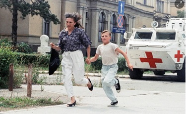 یک مادر و پسرش در امتداد «کوچه تک تیراندازها» به دنبال پناهگاه می‌دوند، ۶ آگوست ۱۹۹۴. عکس: ریکارد لارما/ای‌پی