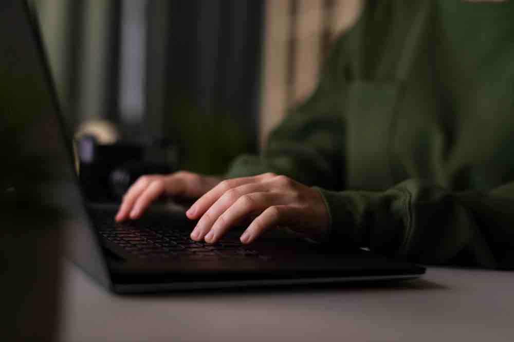 دستان باج گیر زن در حال کار با لپ تاپ