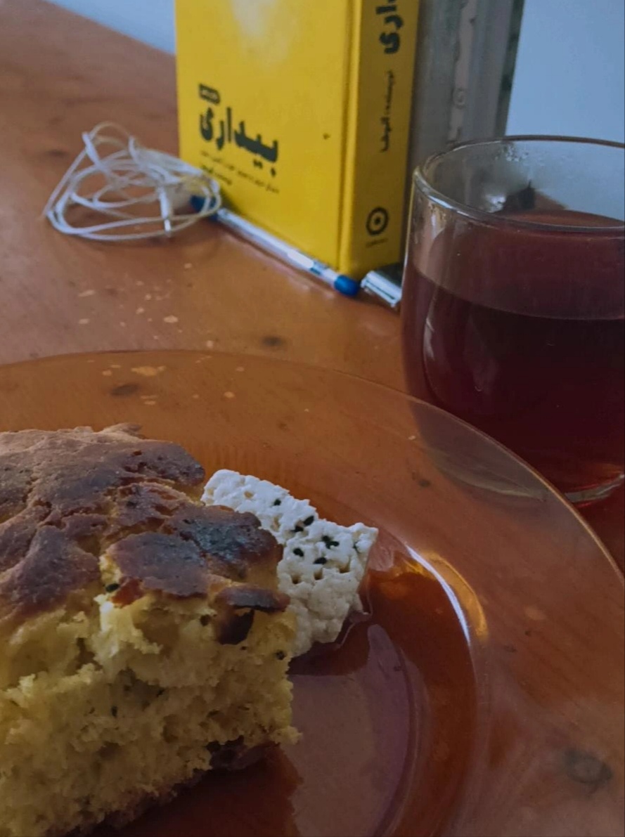 یه گوشهی امن از میز چوبی خونهی خالم امروز بهم رسید. تا کتابامو بزارم، چای بزنم و عکس بگیرم. مامانم خیلی کدبانو عه. این نون که بیشتر شبیه کیکه، کار اونه. خالمم کم کدبانو نیست و این پنیر و با سیاه دونه خودش درست کرده. شمال زندگی کردن خوبیش اینه که چایی های خوبی میتونی بخوری. این چایی هایی که توی فروشگاه ها میفروشن فقططط رنگههه. اصلا قابل مقایسه با عطر چای طبیعی نیست.