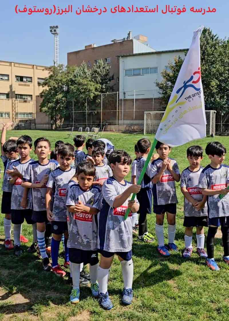 عکس فوتبالیستهای نونهال مدرسه فوتبال استعدادهای درخشان(روستوف)با لباس طوسی خوشحال و پرچم در دست برای شروع فستیوال در زمین چمن