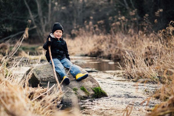   ریچارد، پسر زیبا و زرنگی است. با موهایی بور که به مادرش رفته است. قد کوتاهش هم که از پدرش به او رسیده است. البته مامان سارا خیلی از دست شلوغ‌کاری‌هایش در عذاب است. با همان پای نصف و نیمه‌اش که می‌لنگد ولی جایی از جنگل نبوده که او نرفته باشد. سارا؛ بارها سر این موضوع با آرتور مشاجره کرده بود. - چیکار کنم؟ بگم راه نرو؟! آخه این چه حرفیه میزنی؟ با شرایطی که داره، اگه بگم راه نرو که افسردگی می‌گیره. - نمی‌گم راه نره، منم مادرم ولی می‌گم وقتی ریچارد اینطرف و اونطرف می‌ره نگرانشم. هیچ جنبنده‌ای از دستش راحتی نداره. اون روز یک گربه رو انداخته بود تو گونی، یه سوسک هم انداخته بود داخلش. اگه دیر رسیده بودم، حیوونی خودشو تلف کرده بود. از بس که جیغ کشیده بود. آرتور آهی از سر استیصال کشید، چیزی نداشت که به سارا بگوید. خودش هم بگویی نگویی خسته شده بود. خسته از جواب دادن به دیگر ساکنان جنگل. به خصوص آنهایی که قبل از رودخانه زندگی می‌کردند. شاکی بودند. از بستن پای گاو‌های آقای آشر گرفته تا چسباندن نوک اردک‌های خانم جولیا با چسب.  شبانگاه محوطه‌ی کلبه روشن بود. می‌دانست باز هم ریچارد آتشی به راه کرده است و مشغول تراشیدن بدنه‌ی چوبیِ کِشتی‌اش. علی رغم شر و شوری که داشت بسیار کم حرف بود. هر چه بارش می‌کردند کلامی از او درنمی‌آمد. لیوانی از خانه برداشت و رفت کنار ریچارد. - سلام پسر! اما ریچارد، حتی به صورت پدرش نگاه هم نکرد. آرتور، کتری سیاه رنگ را از کنار سنگ‌های داغ برداشت. - به به! باز هم شیر! خوشم میاد ازت که به خودت می‌رسی. ریچارد سرش را از کِشتی بلند کرد اما هیچ نگفت. هیچ! دست از کار کشید. - چیه باز اومدی نصیحتم کنی؟ - نصیحت که نه، اومدم اِاِاِاِ اومده بودم تو خنکی هوا کمی با هم گرم بگیم و گرم بشیم. با مشتش آرام به کتف ریچارد کوفت. - نظرت چیه پسر؟! چشمان آبی‌اش را به سرخی آتش دوخت و گفت: «چند بار بگم؟ اونا لنگیدنم رو مسخره می‌کنن. منم اینطوری انتقام می‌گیرم.» لیوان شیر را سمت ریچارد می‌گیرد. چشم در چشم می‌شود. با دستش شانه‌ی افتاده‌ی پسرش را می‌مالد. سرش را پایین می‌اندازد. - می‌دونی ریچارد؟! همش، اِاِاِ لبانش را می‌گزد. - همش این نیست. حیوونای جنگل چی؟ اونام مسخره می‌کنن؟! چانه‌ی ریچارد لرزید. قطره‌ای اشک از گوشه‌ی چشمش روی گونه‌هایش غلطید و از زیر چانه روی لباسش افتاد. مسیر ریزش اشک، زیر نور آتش، می‌درخشید. - تا حالا شده به تنهایی منم فکر کنی؟ تا حالا شده بذاری منم تو کارها بهت کمک کنم؟ تا حالا منو شریک خودت کردی؟ باهام حرف زدی؟ هر وقت گِلِه داری میای پیشم. سارا هم همینطور. مدرسه هم که نمی‌تونم برم. سکوت خونه هم که به دلم چنگ میز‌نه. با خشم به آرتور نگاه کرد. - تو برام چه کار کردی؟! بگو! کشتی رو سمت آتش پرتاپ کرد. آرتور به سمت آتش دوید، بلکه بتواند کشتی را از سوختن در آتش غضب ریچارد نجات دهد.   🖌 رسول کامبیزی