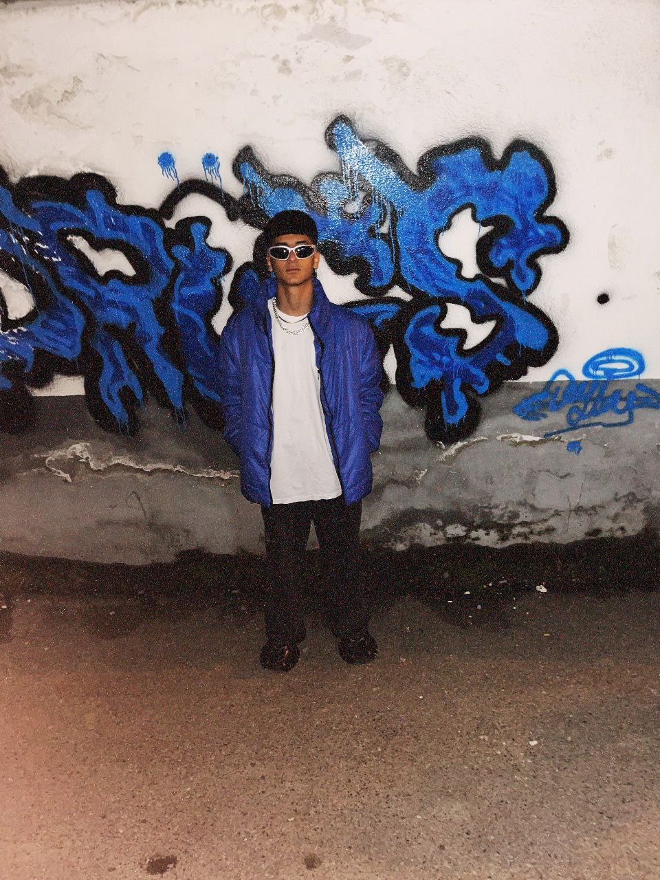 A photo of Wayne Target, a folk singer from Leningrad. He started singing at the age of 13. He grew up playing the keyboard for a long time in music and now he has reached where he wants to be. Everyone likes Wayne Target. In his song, he says "Kaf Nors" or "013".