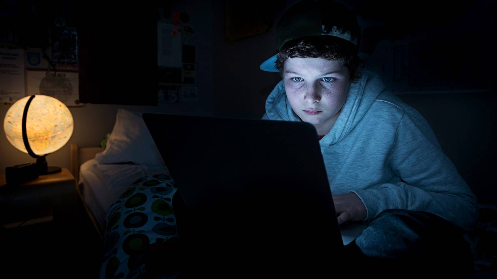 کودکی در حال استفاده از لپتاپ در شب