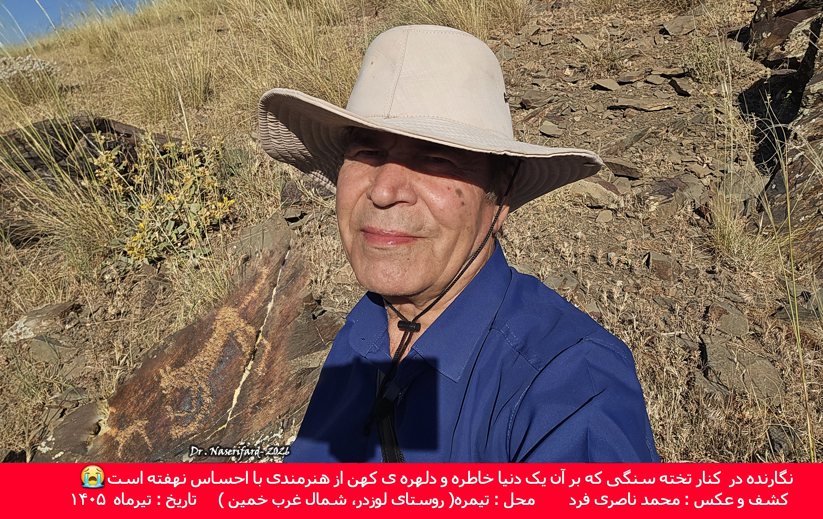 نگارنده در کنار تخته سنگی که برآن نقاشی یک یوز پلنگ در تعقیب بچه آهو آفریده شده است.